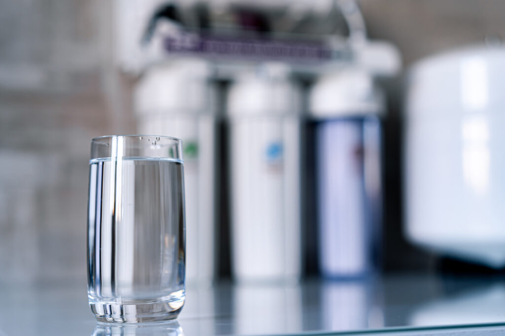 A clear glass of water on a glass counter.