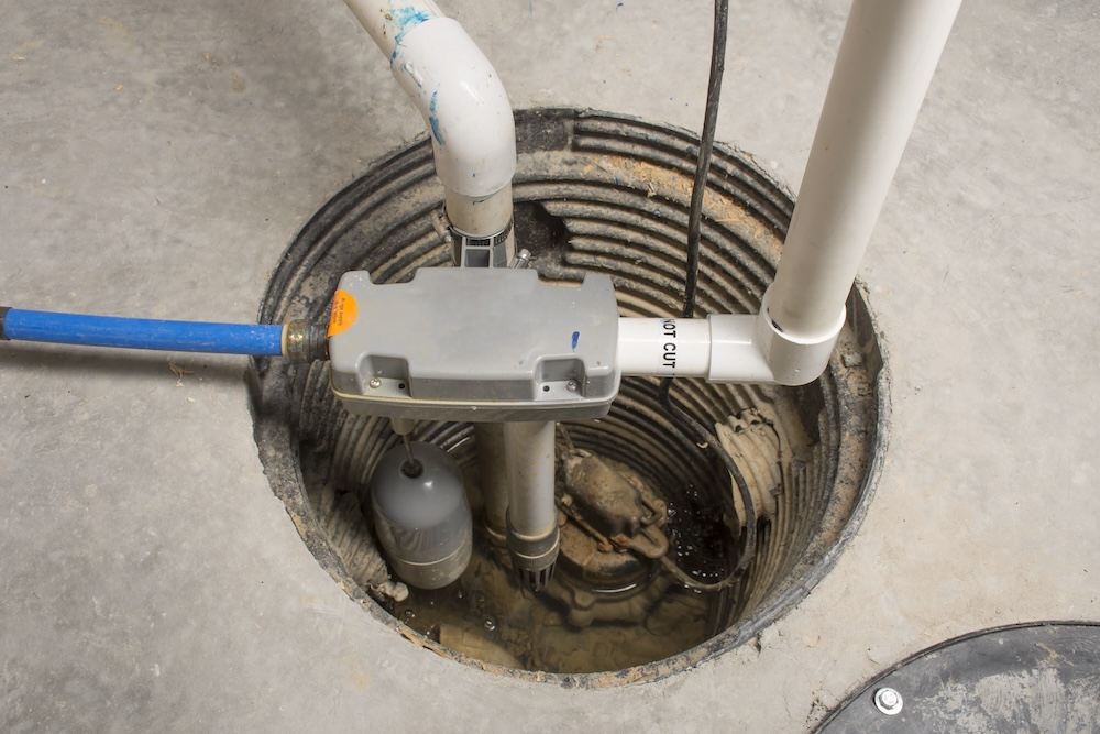 A sump pump installed in a basement of a home with a backup system.